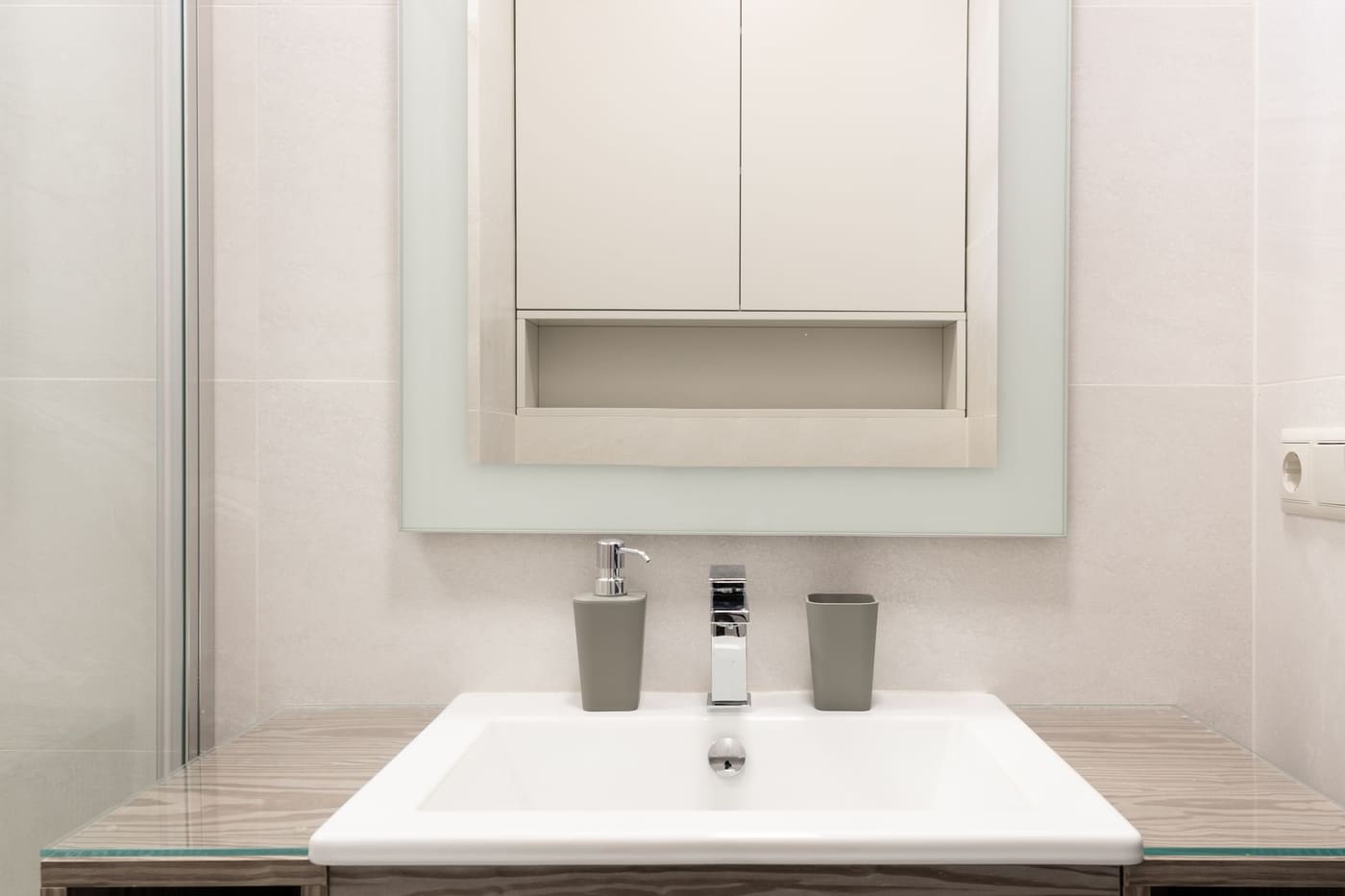 Bathroom sink with a mirror and a wall cabinet with an open shelf above
