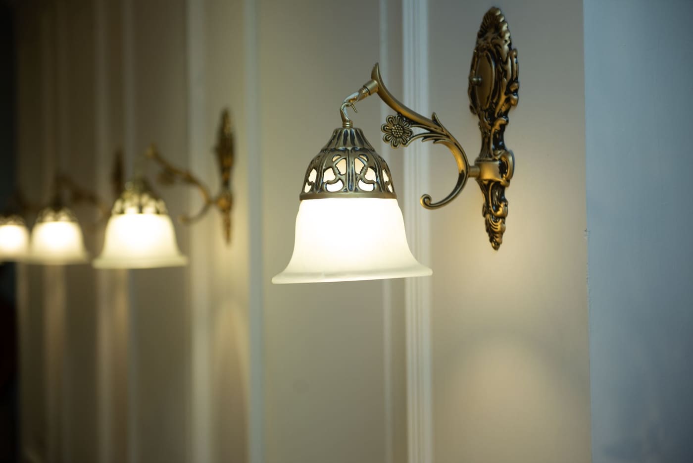Brass wall sconces with frosted glass shades giving off soft light