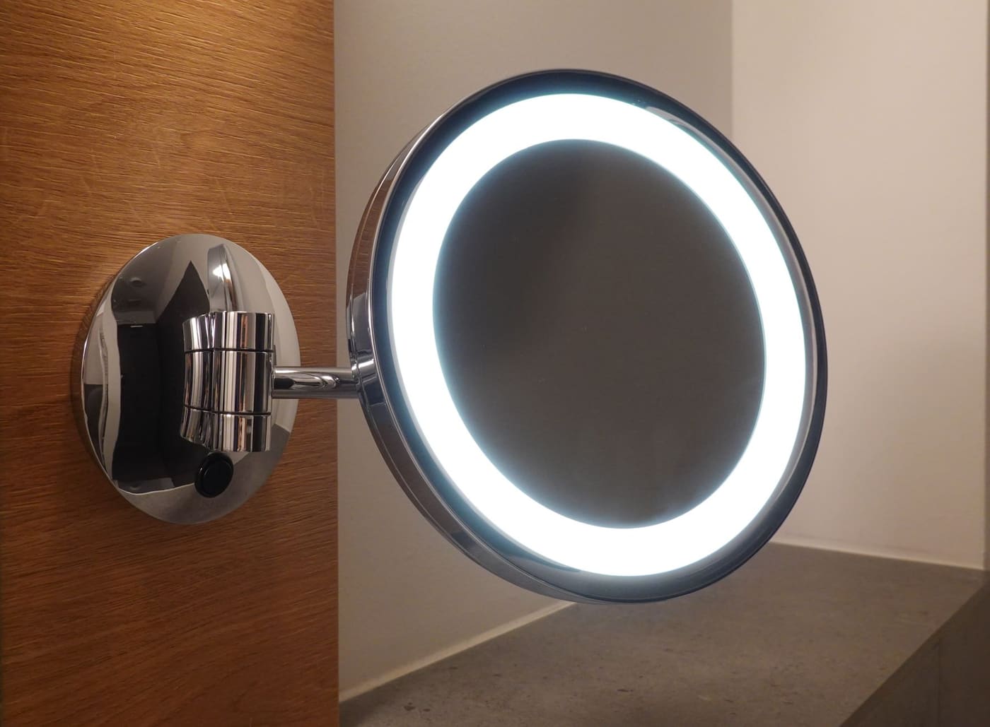 Wall-mounted chrome magnifying mirror with a ring of LED light