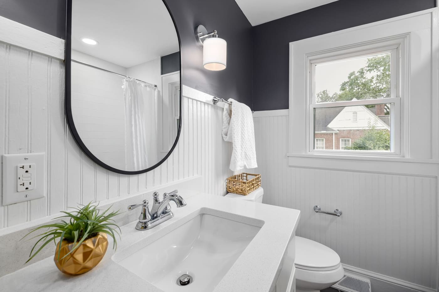 Bright bathroom with a large mirror, window and clear counter