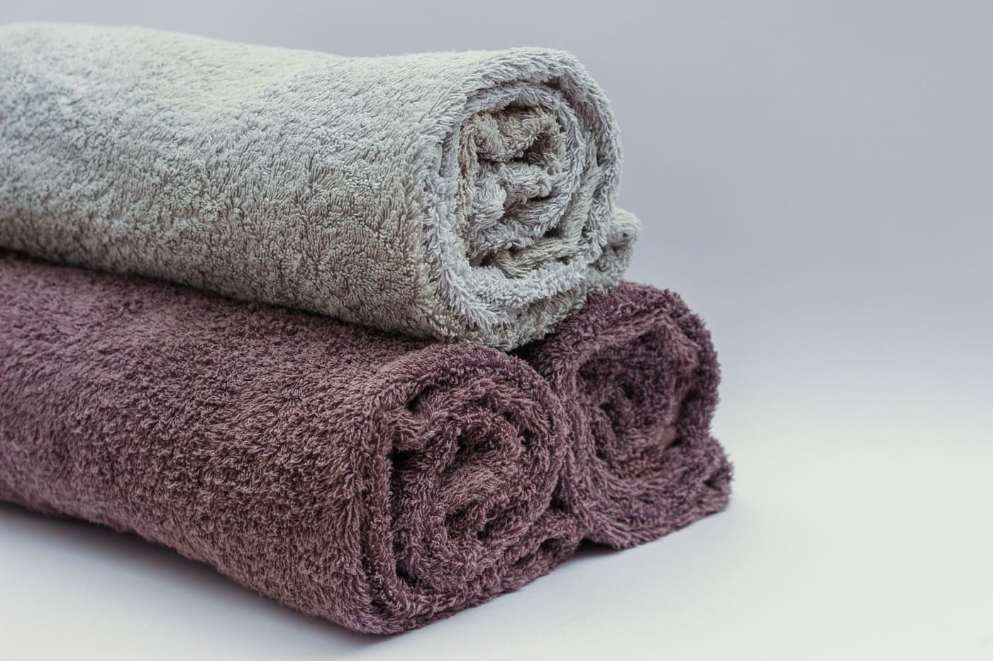 Rolled towels in neutral tones stacked in a pile