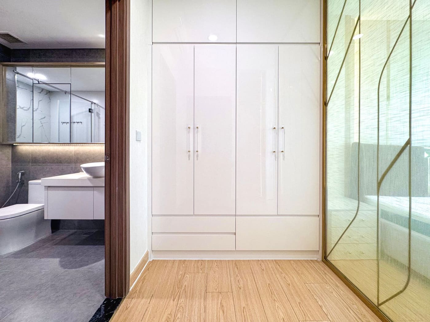 Tall white closed cabinets beside a bathroom doorway